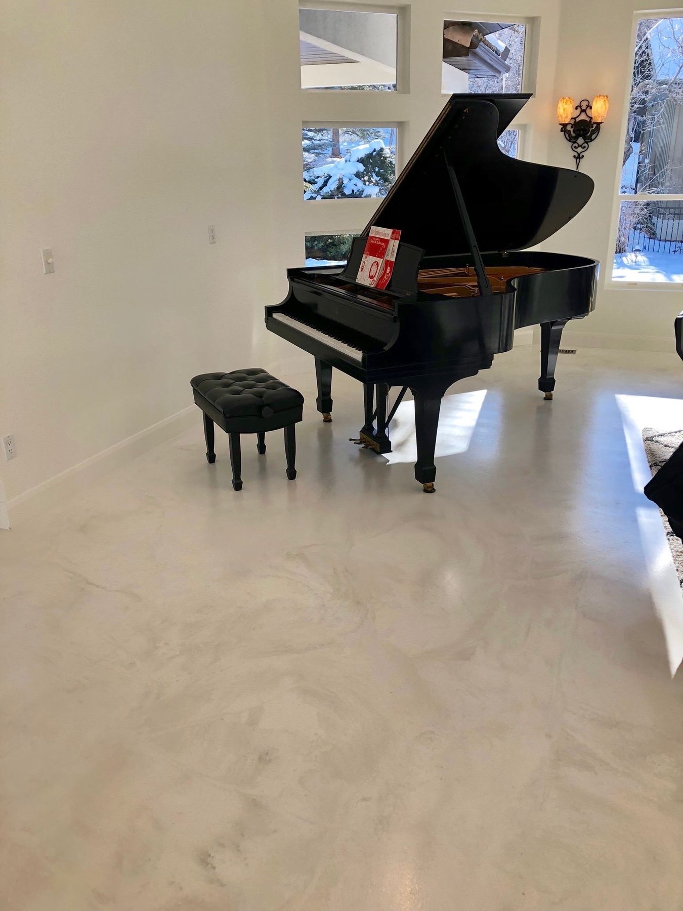 Marble-look hand-troweled microcement floor in a Nashville living room with a grand piano