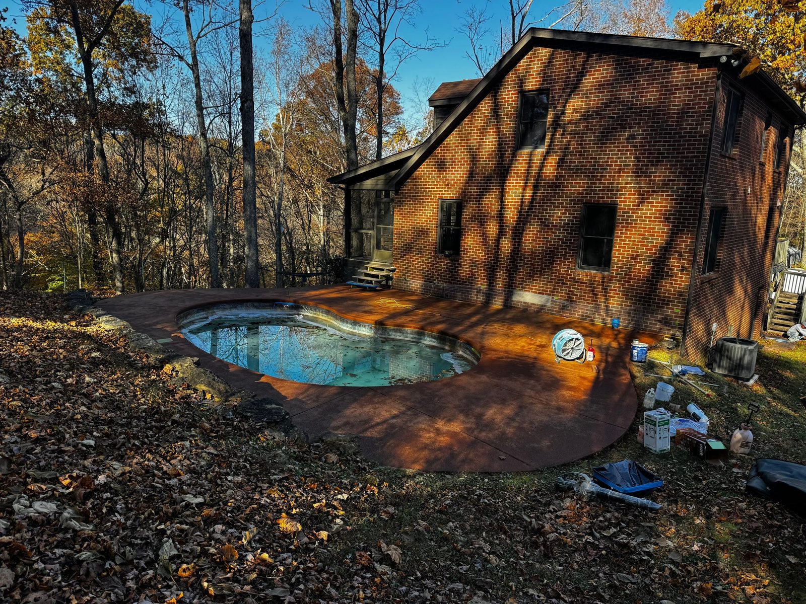 Freeform pool deck in Ashland City cleaned, stained a warm tone, and sealed